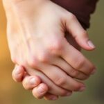 Two hands holding each other, symbolizing trust and connection.